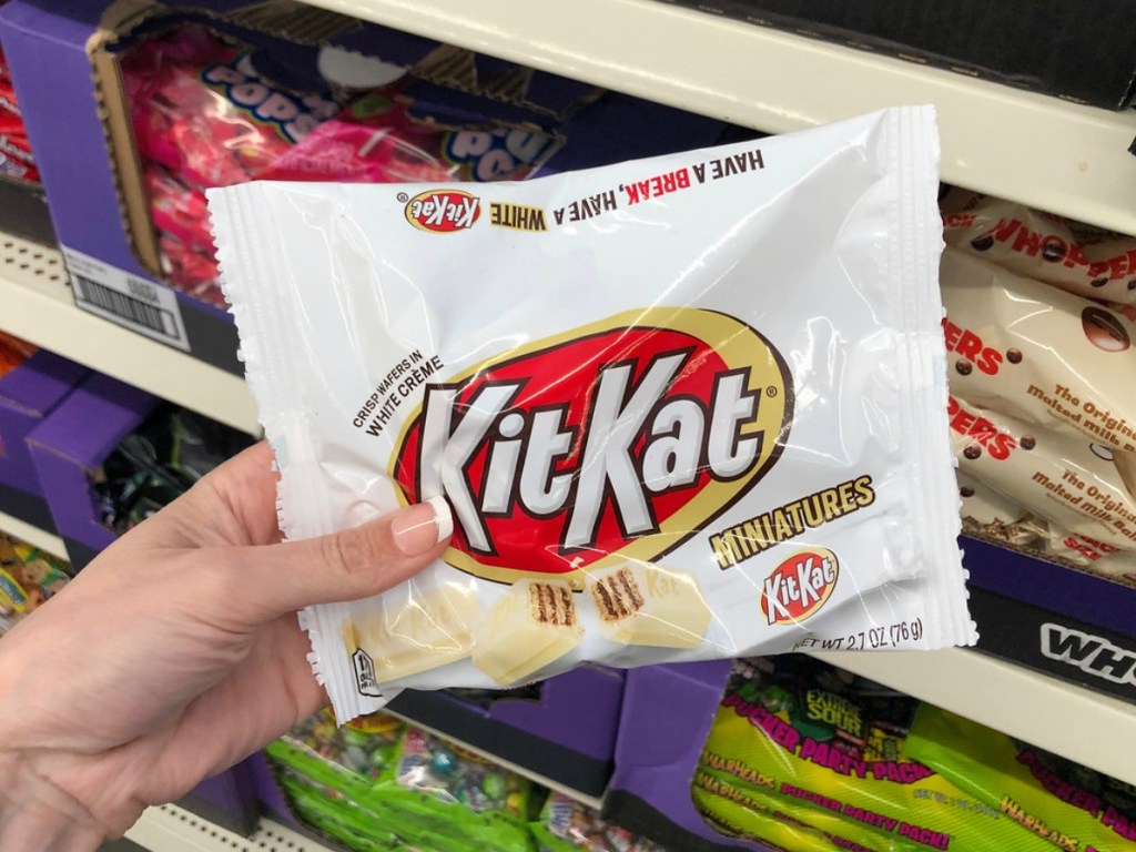 hand holding bag of kit kat candy in store