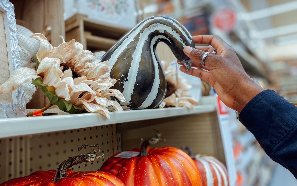 hand holding a gourd on store shelf