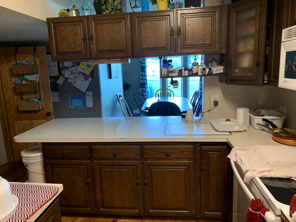 kitchen beforehand with brown cabinets and old countertop