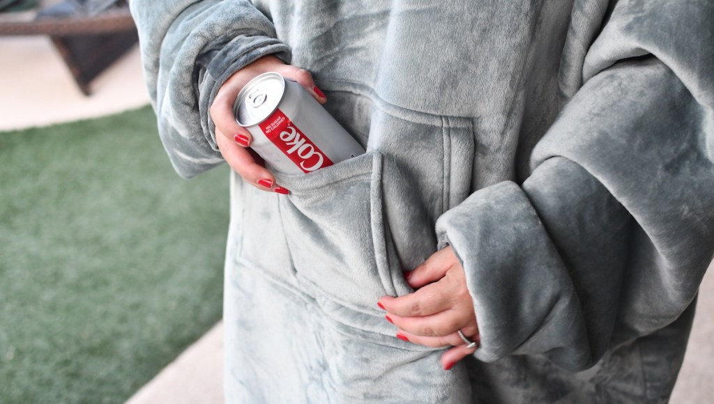 hand taking coke out of gray hoodie 