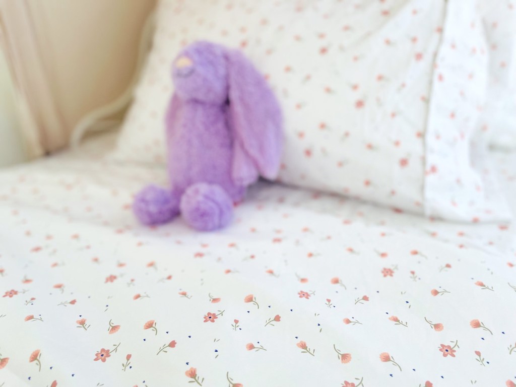 patterned sheets with pink flowers and purple stuffed bunny