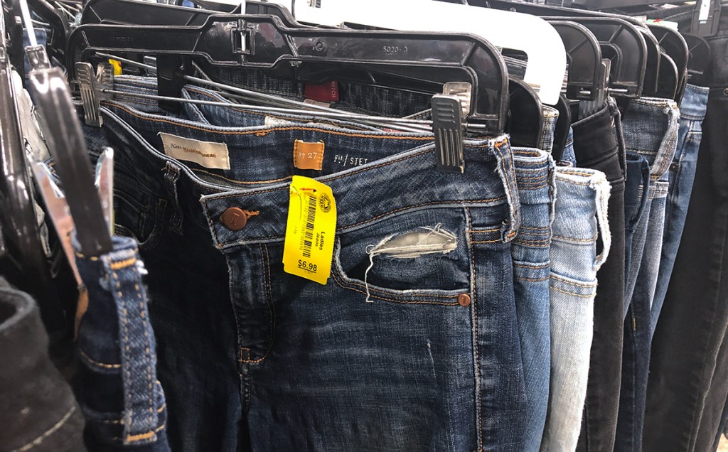 designer pilcro jeans on rack at thrift store filled with sustainable products and eco friendly products