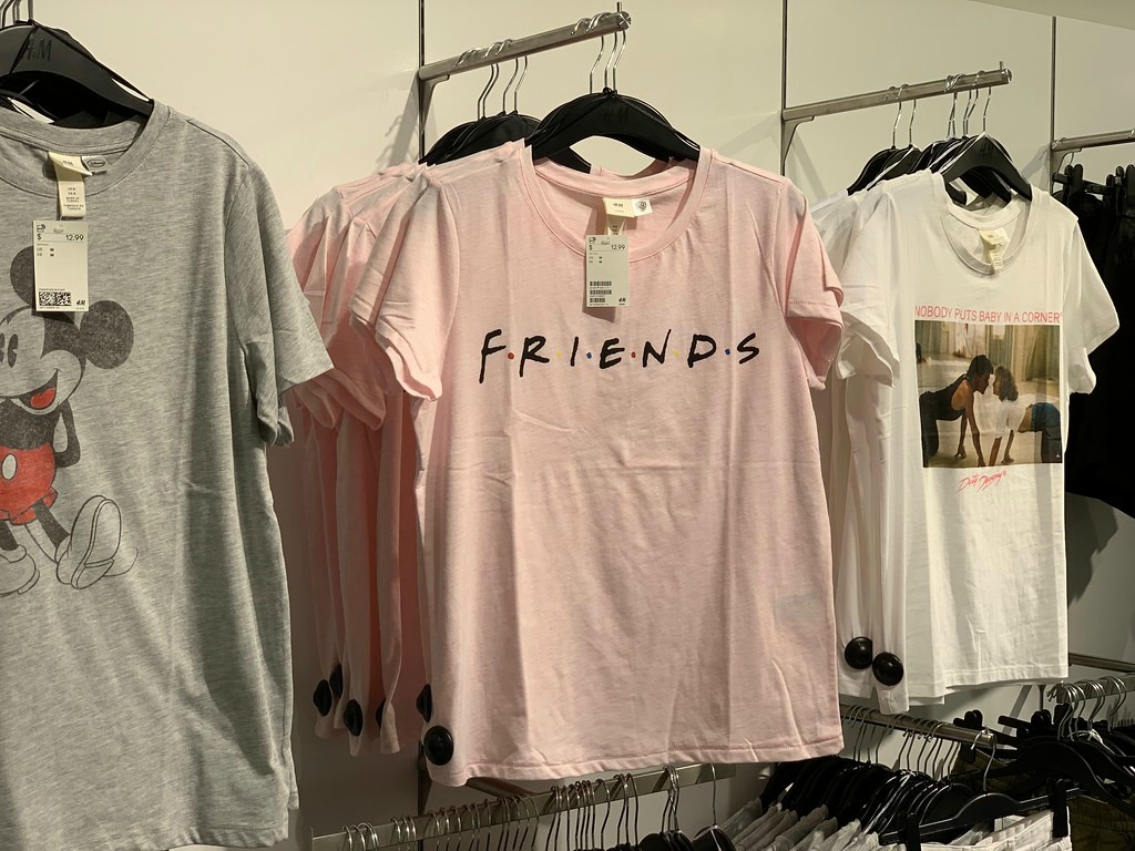 pink friends logo t-shirt hanging on a store wall