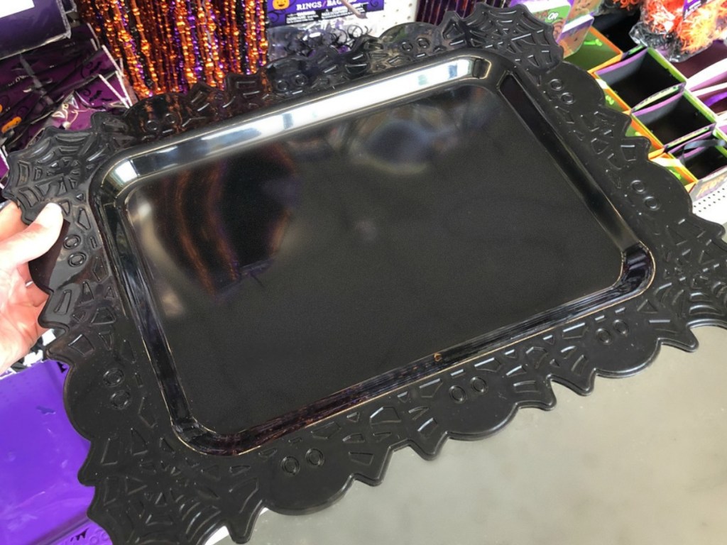 black tray being held by hand in store