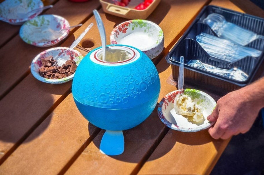 round blue ice cream maker on picnic table