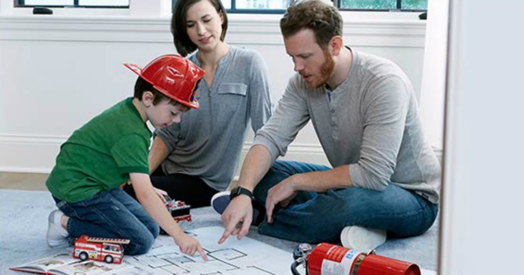 family sitting on rug discussing fire safety