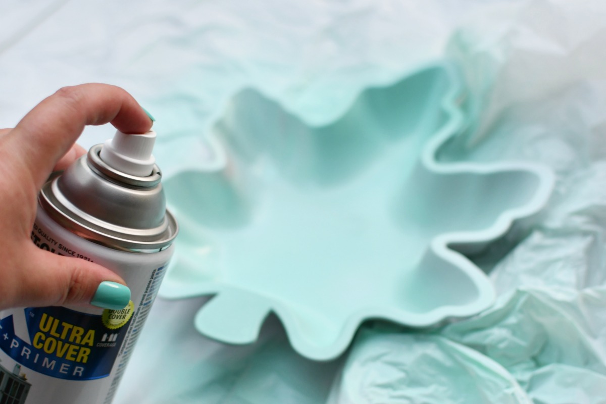 spray painting a plastic leaf blue