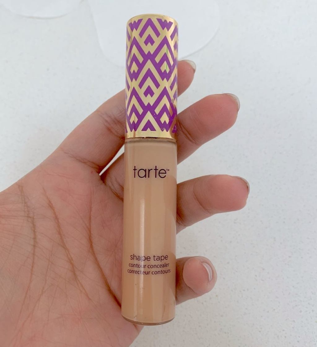 hand holding a tarte concealer beauty products