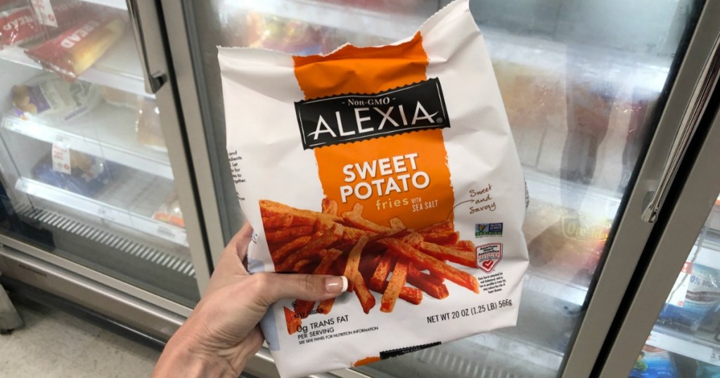 Bag of sweet potato fries in hand in-store in front of freezer display