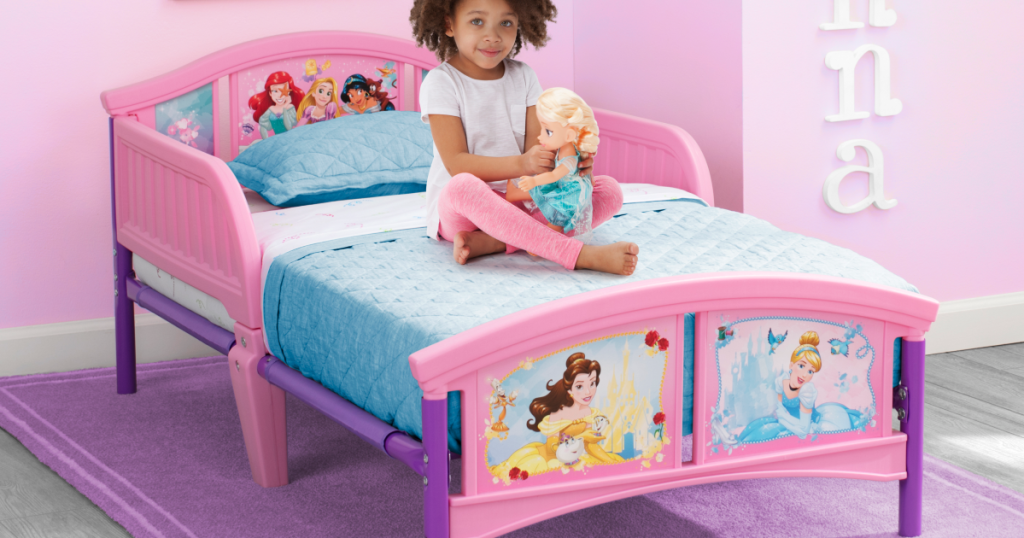 disney princess bed with little girl sitting on it