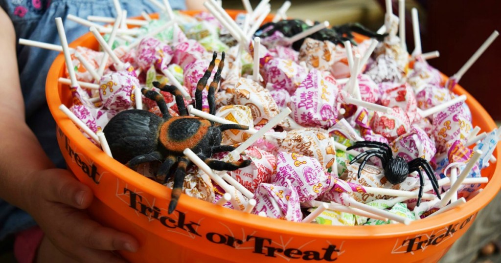 Dum Dums lollipops in trick or treat bowl with plastic spiders