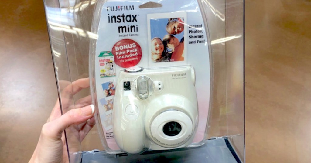hand holding a white fujifilm camera in clear case