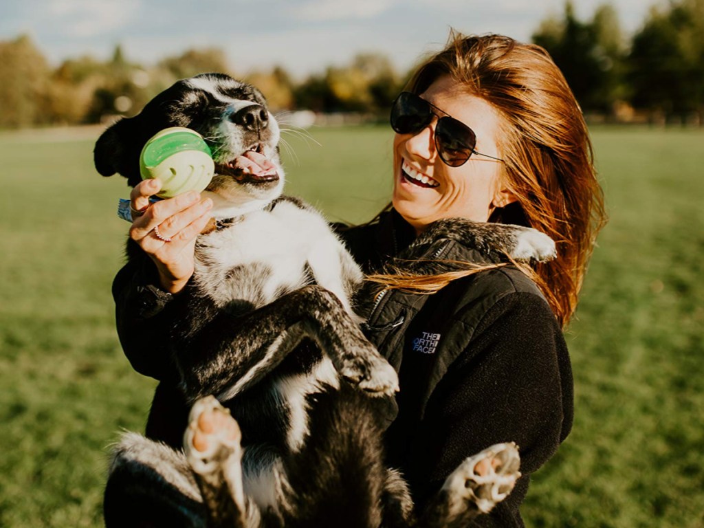 Woman holding pup with hyper pet dura sqeaks toy 