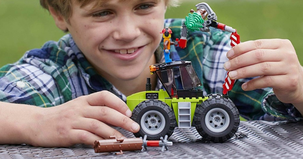 Kid playing with LEGO forest building set