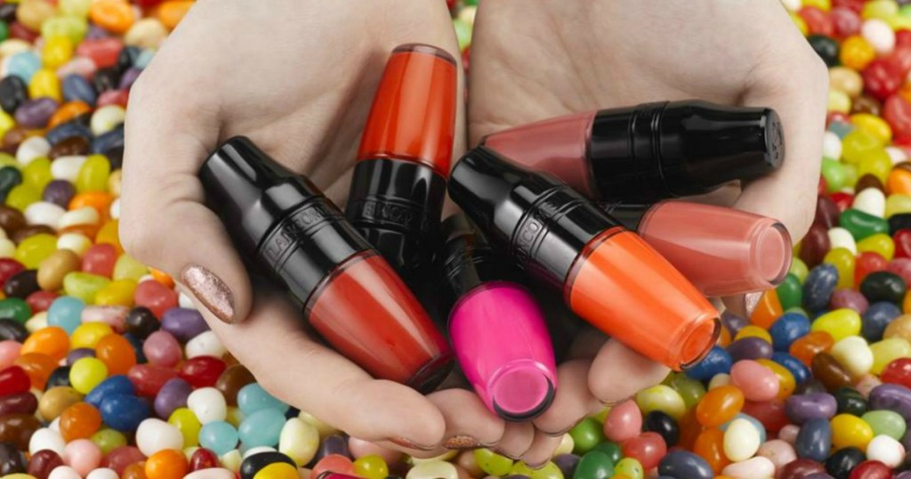 Lancome lip shakers in hands surrounded by jelly beans