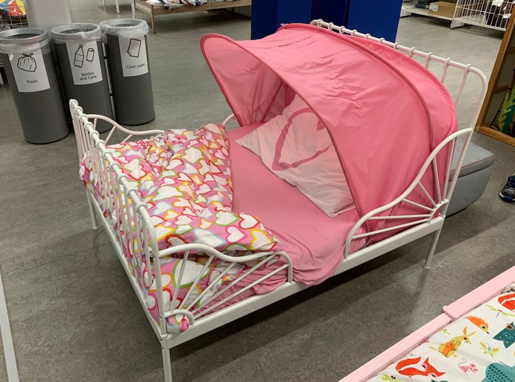 Minnen white iron toddler bed with pink canopy tent on top
