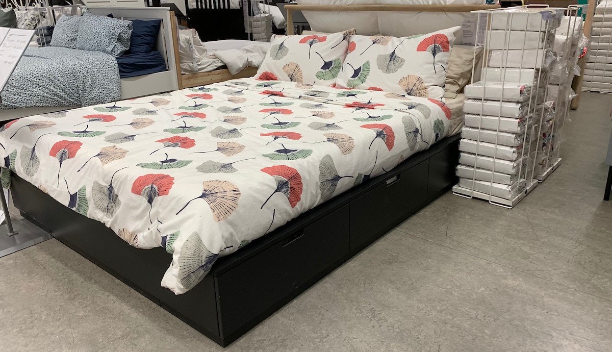 platform storage bed with floral comforter in store