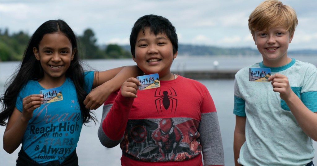 three kids holding up their National Park Pass