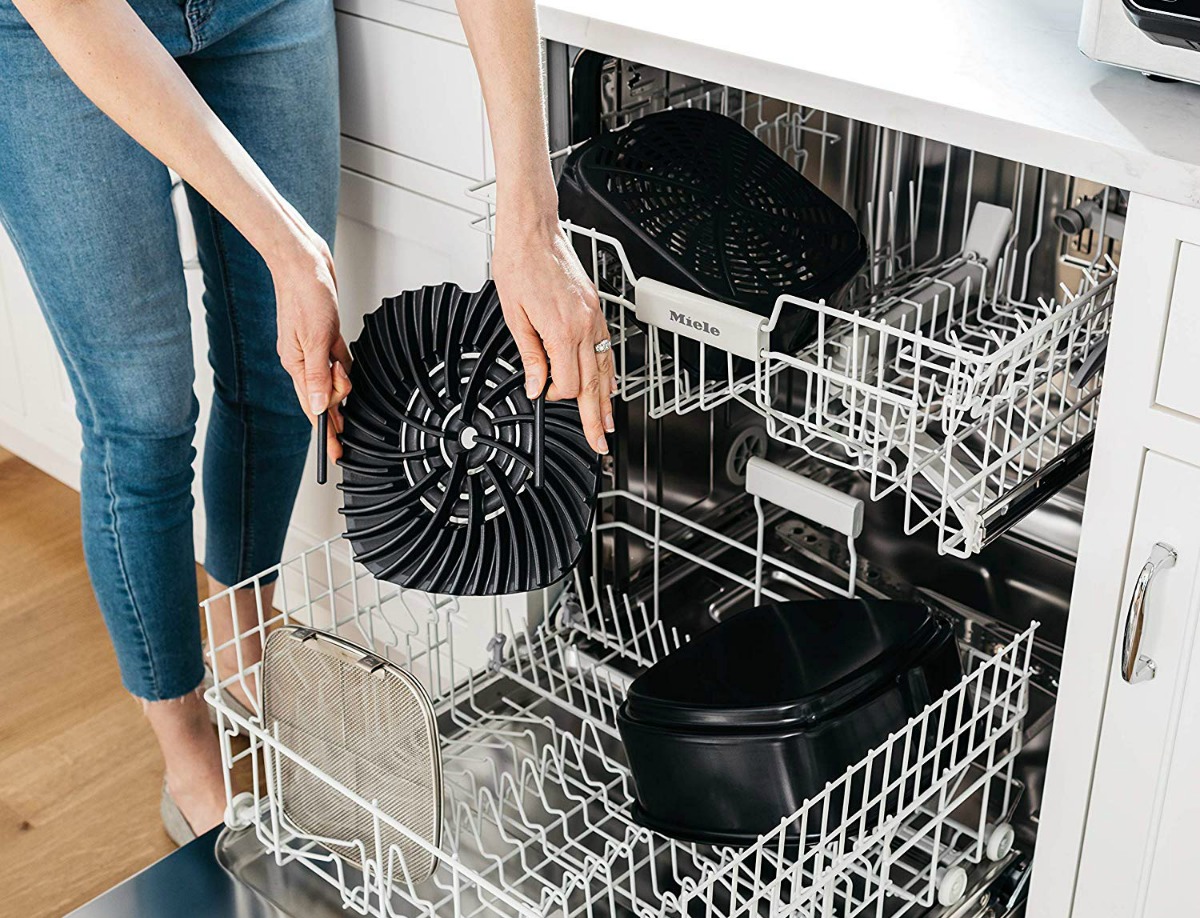 woman putting Ninja Foodi Grill part in a dishwasher