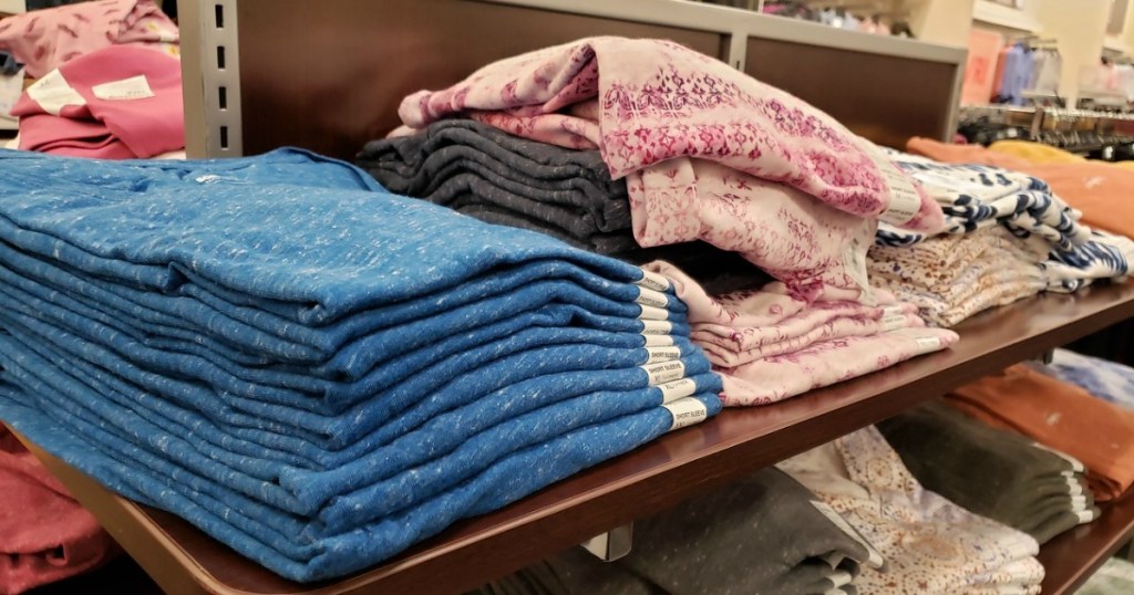 women's tees folded on store shelf