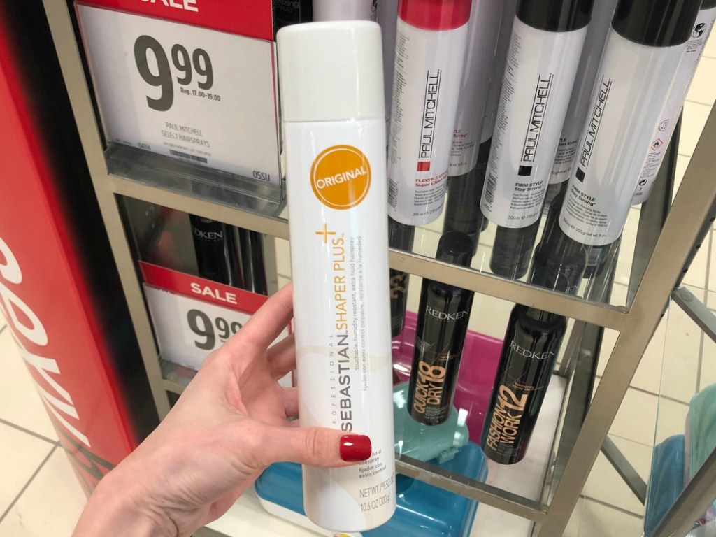 Sebastian Shaper 10.6-Ounce Hairspray in hand in JCPenney in front of the display