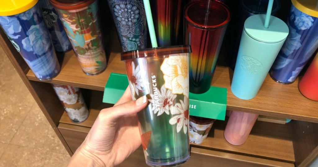 Starbucks brand tumbler with floral summer print in hand in-store at Target