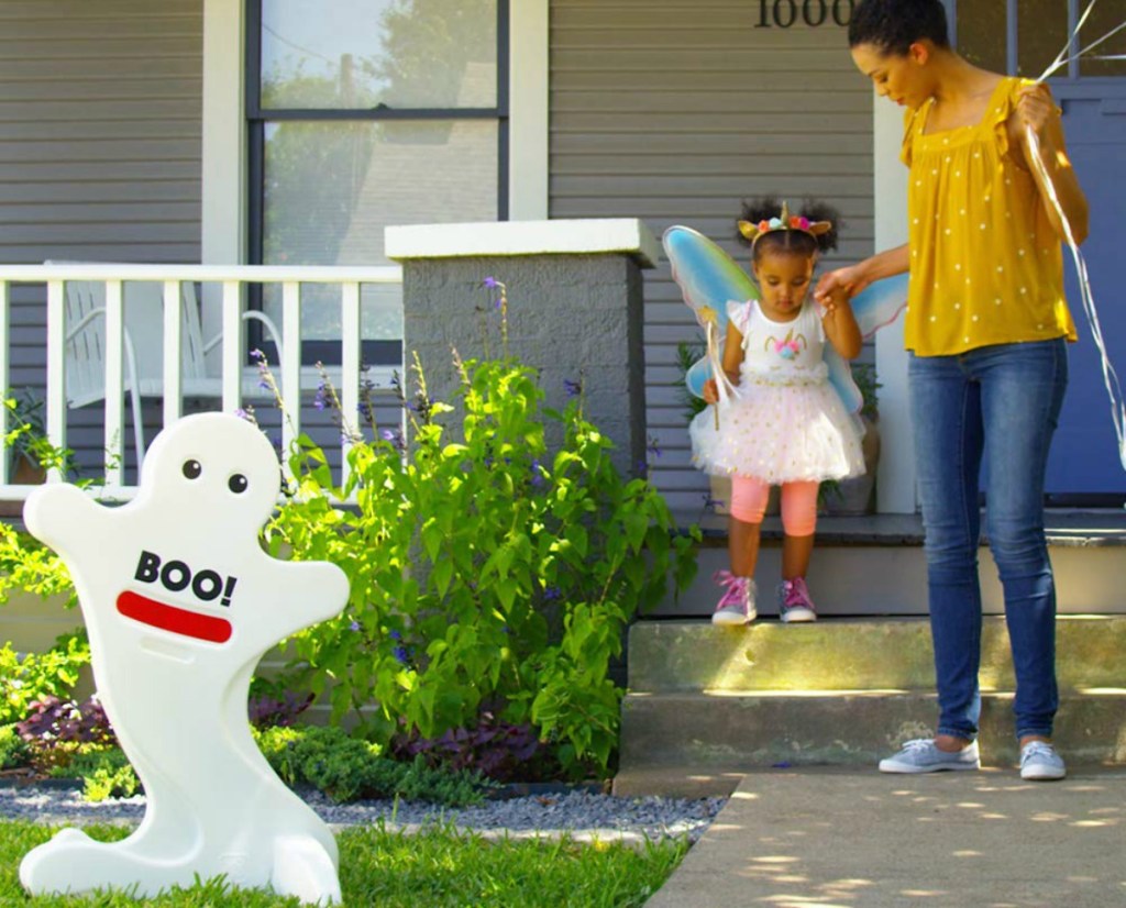 woman and little girl stepping off porch to go trick-or-treating