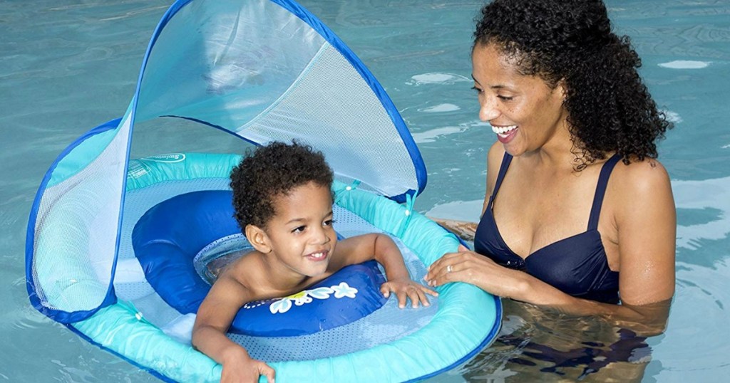 Young child in a blue float with canopy in pool with his mom