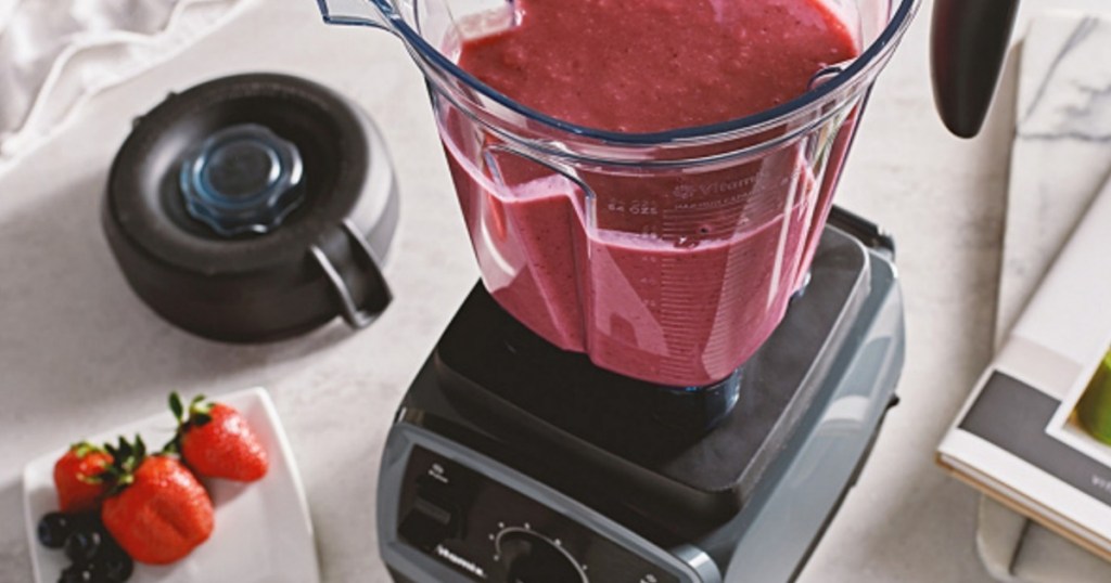 Vitamix filled with strawberry smoothie and top off