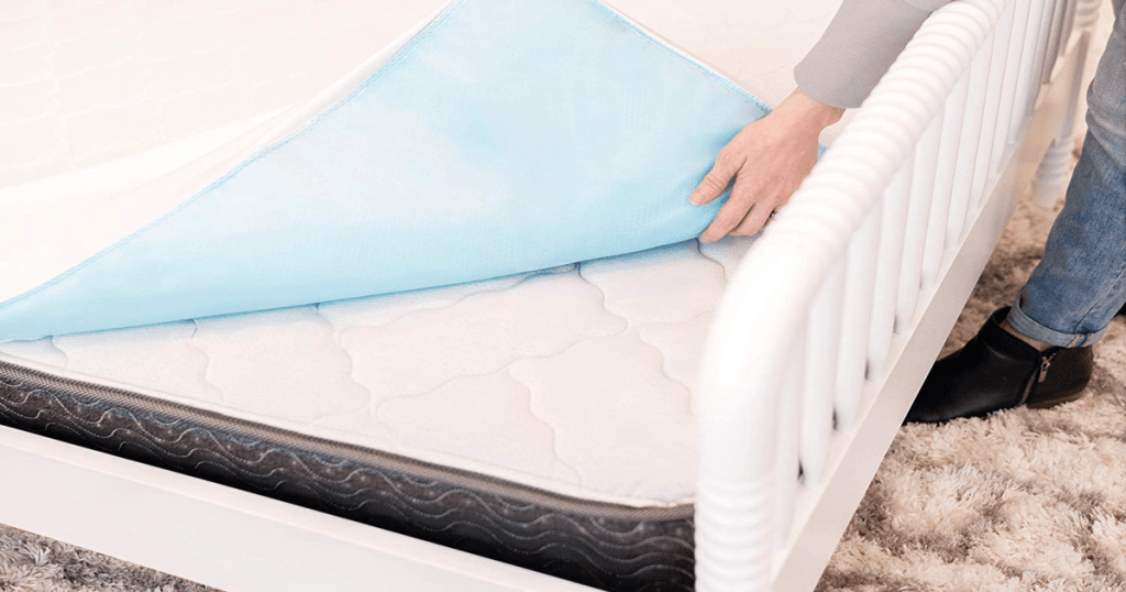 woman putting mattress protector on kids bed