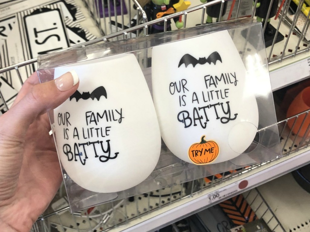 hand holding package of halloween theme cups by store display