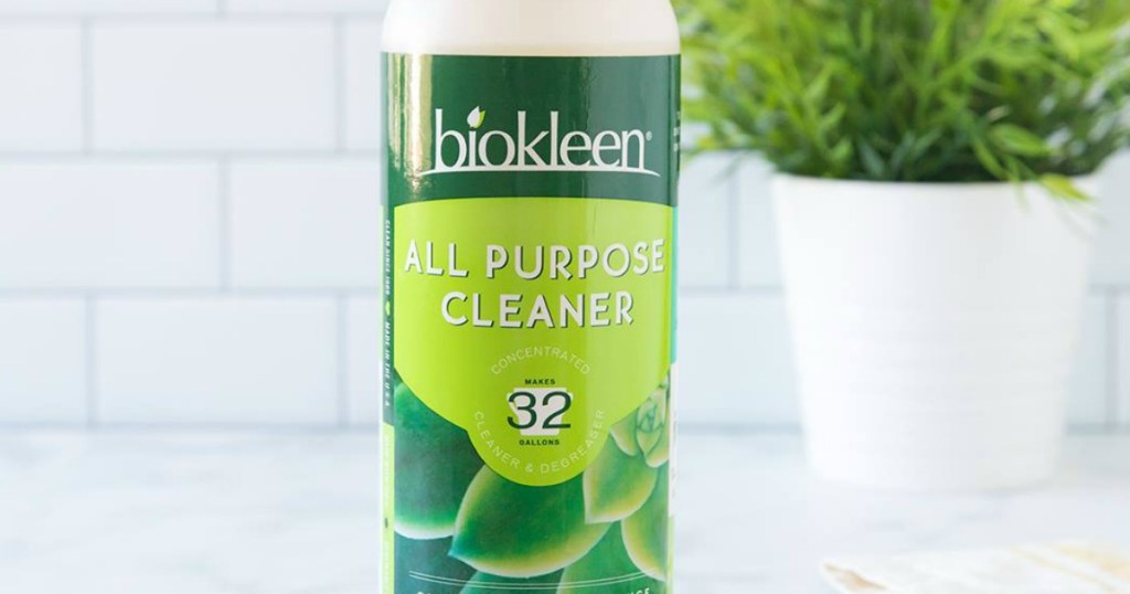 Large bottle of biokleen all purpose cleaner on counter with plant near tiled back-splash 