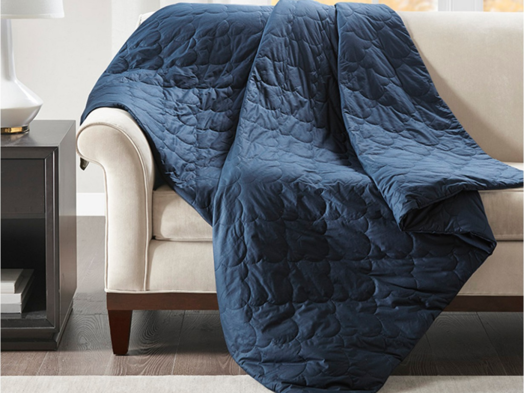 blue weighted blanket thrown over the couch