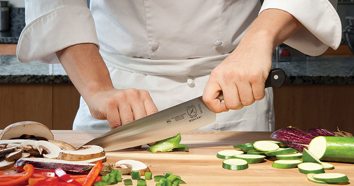 chef using mercer knife to chop vegetables