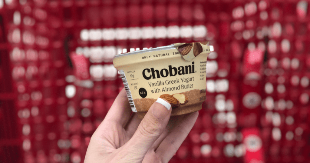 hand holding chobani yougurt with blurry target cart in background