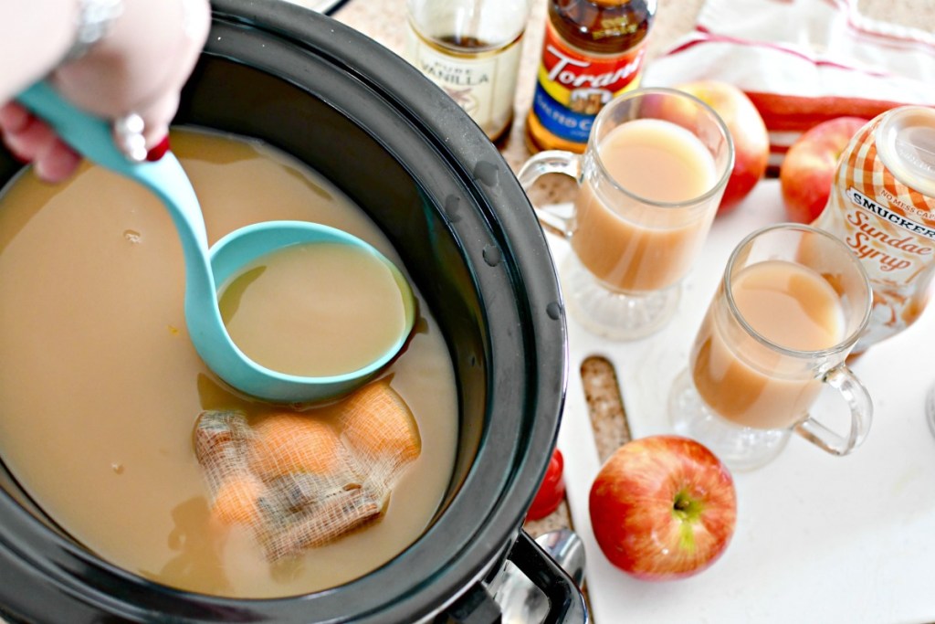 dishing up a glass of slow cooker cider