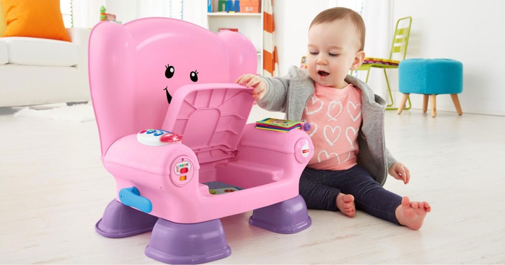baby sitting in a room playing with the fisher-price laugh and learn pink chair
