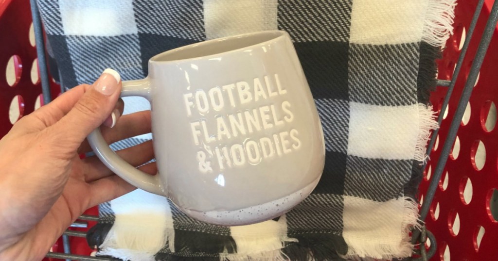 hand holding mug by flannel scarf