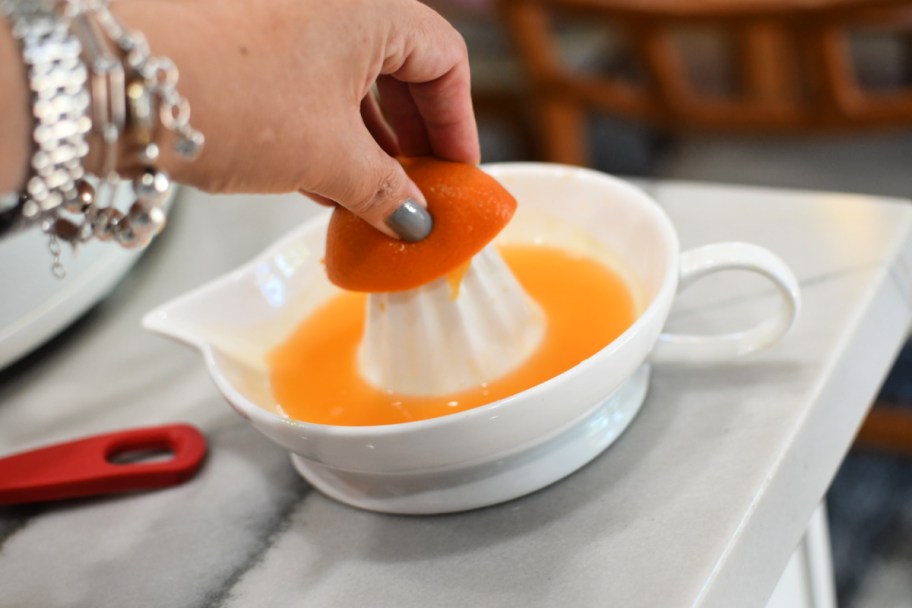 juicing an orange using a hand juicer