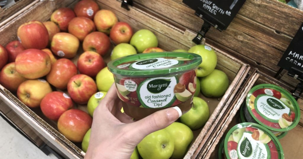 hand holding marzetti Caramel Dip near apples