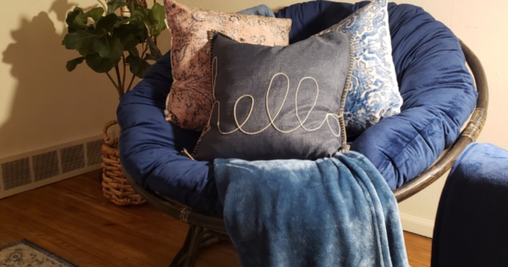 chair with blue cusion and pillows on it
