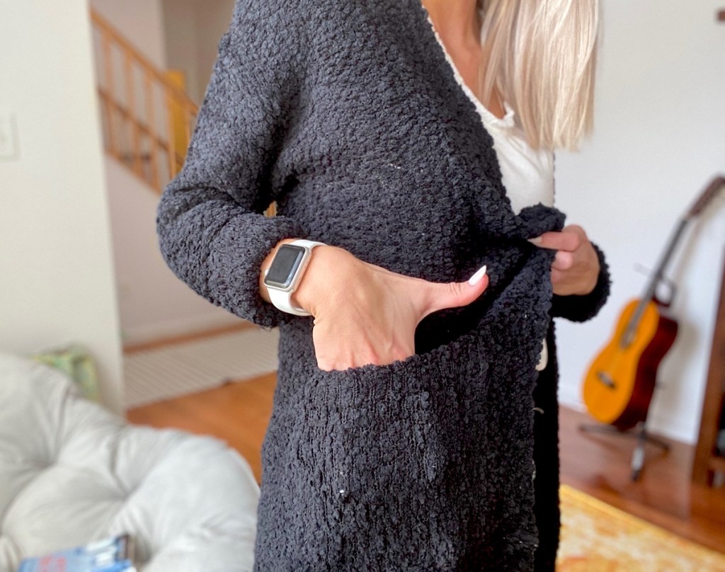 woman wearing black cardigan sweater with hand in pocket