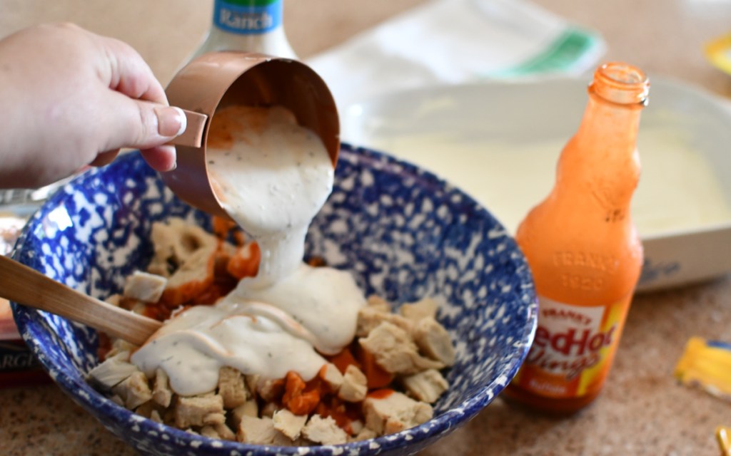 pouring ranch onto shredded chicken