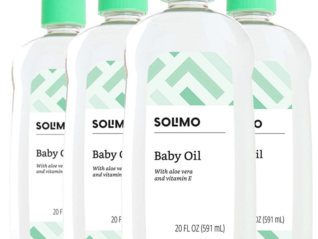 four bottles of baby oil with green caps and black writing on them