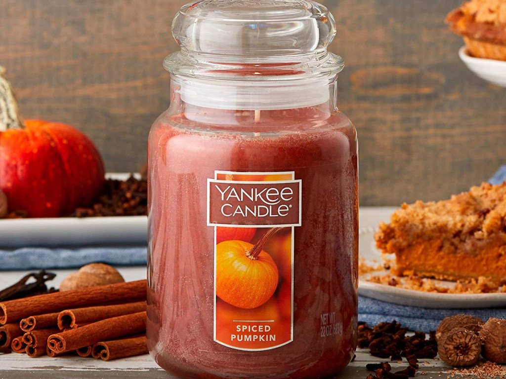 yankee candle spiced pumpkin with cinnamon, pumpkin and pie behind it