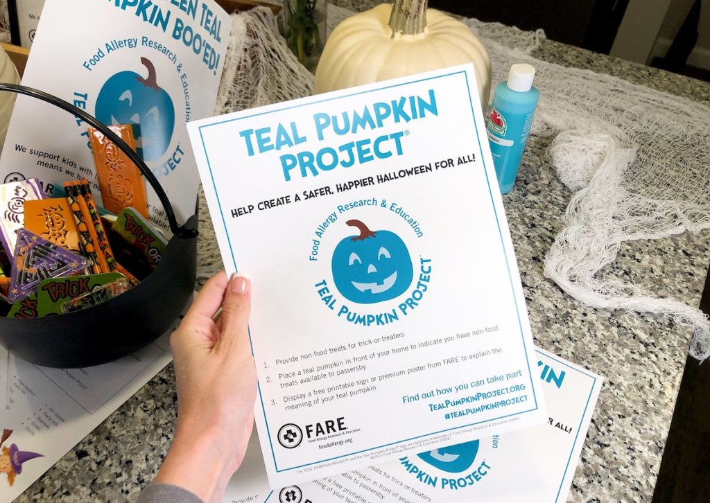 hand holding teal pumpkin project halloween print out