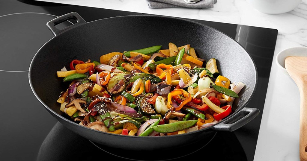 wok with handles on flat stove with ingredients in pan