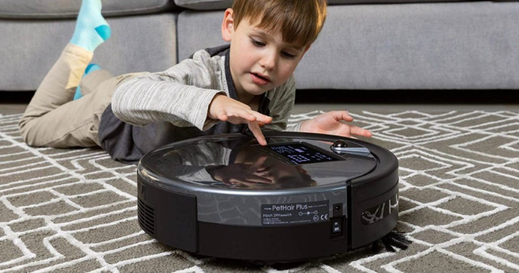 boy child playing with Bobsweep PetHair Plus Robotic Vacuum on carpet