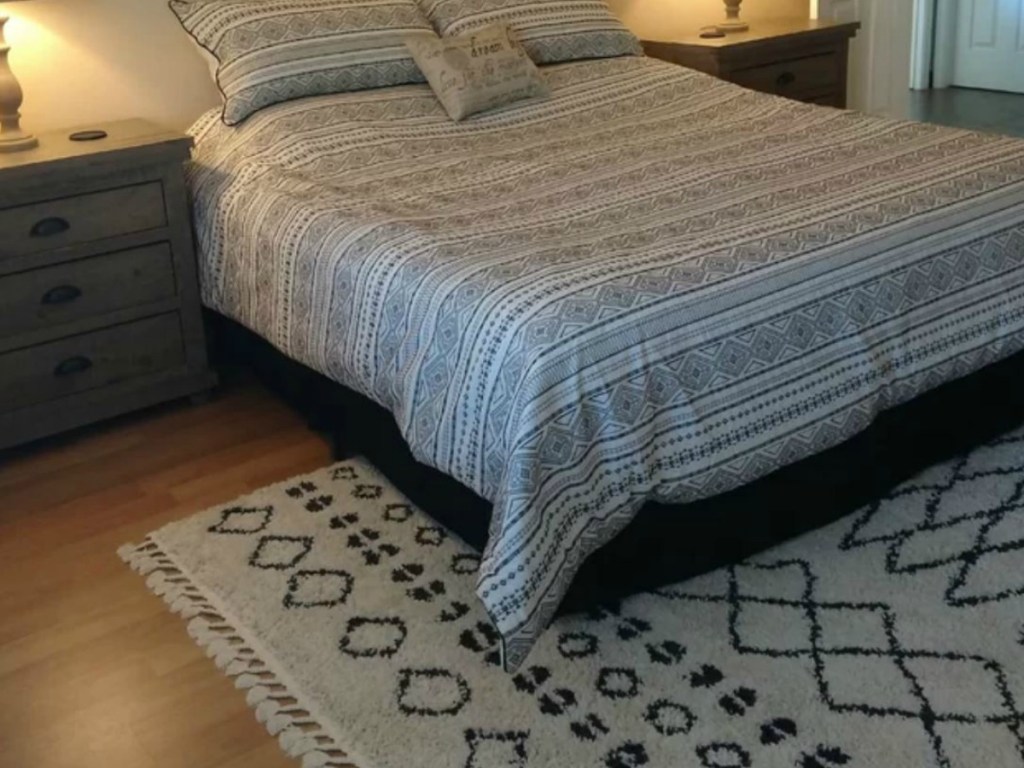 bed with side table and rug on hardwood floor