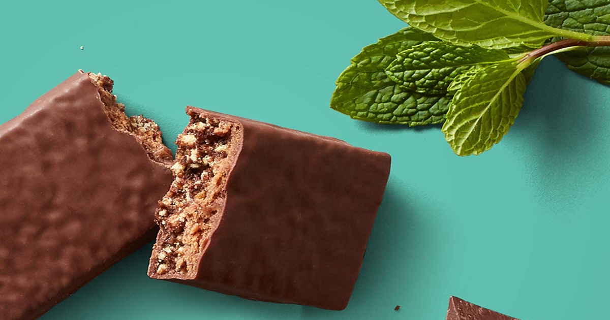 Chocolate Mint Clif Builders bar, broken in half with a mint leaf on the right side of the image